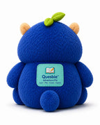 Back view of the blue Quesbie Adventure Pal plush showing its green label, small tail and leaf tuft.