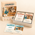 Open Vamos! game box with bakery card stacks and Spanish greeting cards arranged in front.